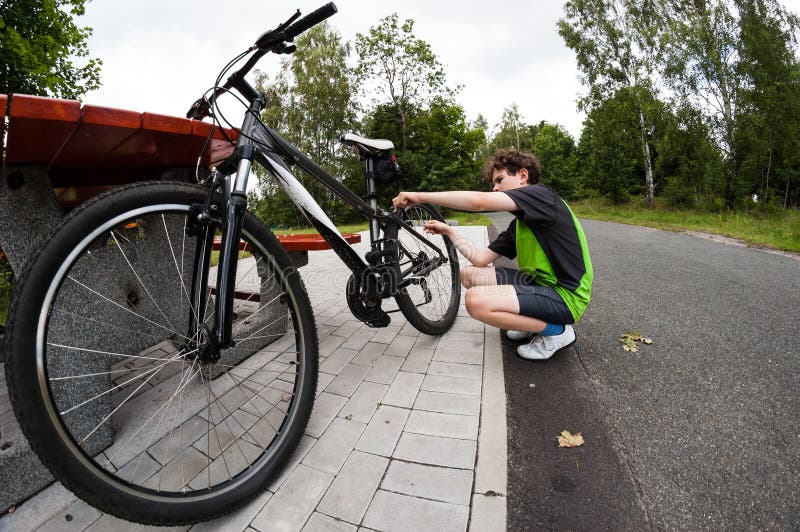 Boy repairing bike on track stock photo Boy repairing bike on track stock photo