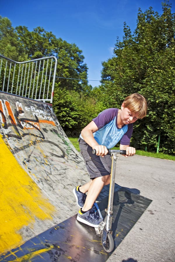 Boy rides scooter in a pipe