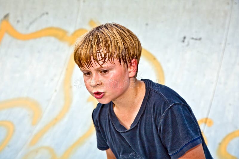 Boy rides scooter in a pipe at a skate park