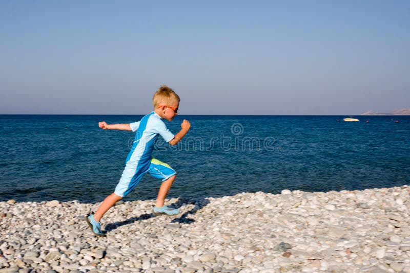 Boy running on gravel beach