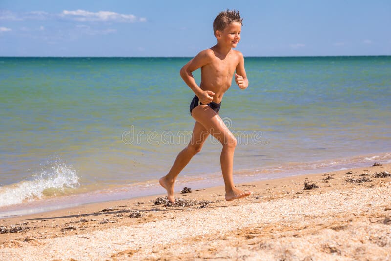 Boy running from sea on beach