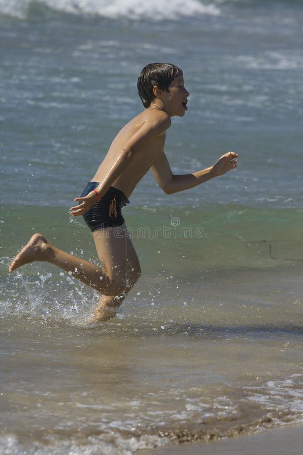 Boy running in sea waves