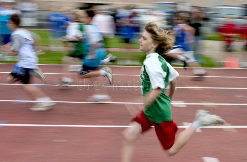 10 year old boy running at a track and field meet. Motion blur to convey speed. 10 year old boy running at a track and field meet. Motion blur to convey speed.