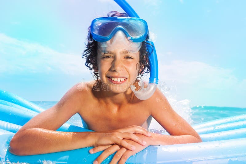 Boy with scuba mask swim on matrass in the sea