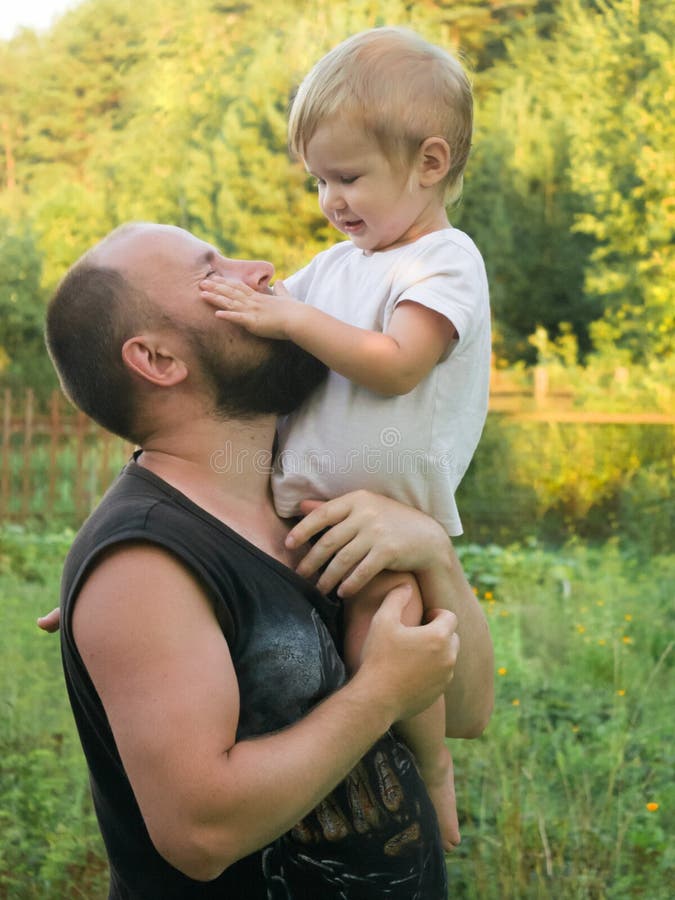 The boy sits on his father`s shoulder. 