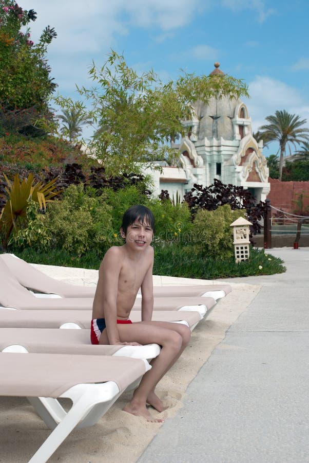 Boy sitting on a beach bed