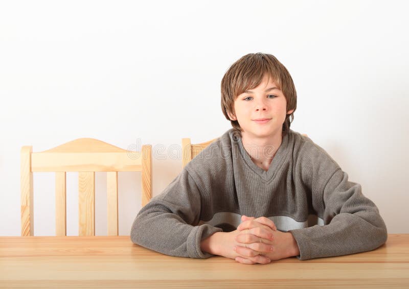 Boy Sitting Behind Wooden Table Stock Photo Image of chair, table