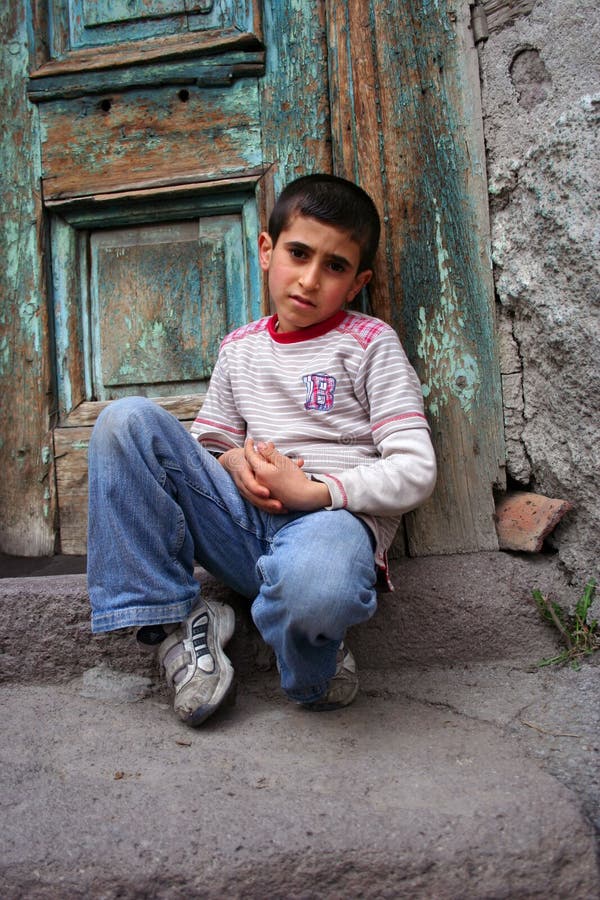 A boy sitting at the doorstep