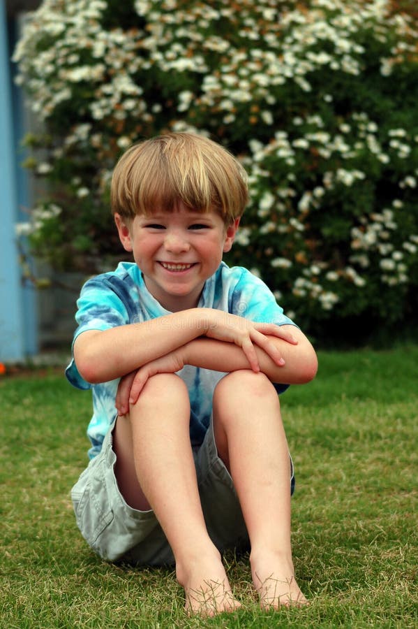 Boy sitting down in grass stock image. Image of happy - 1427941