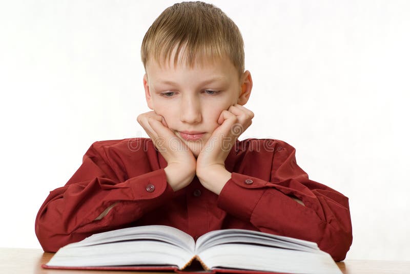 Boy is sitting and reading a book