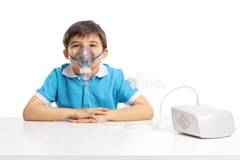 Boy sitting at a table with inhaling mask royalty free stock images Boy sitting at a table with inhaling mask royalty free stock images