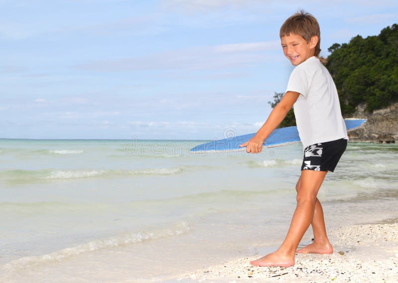 Boy with skim board on sea background