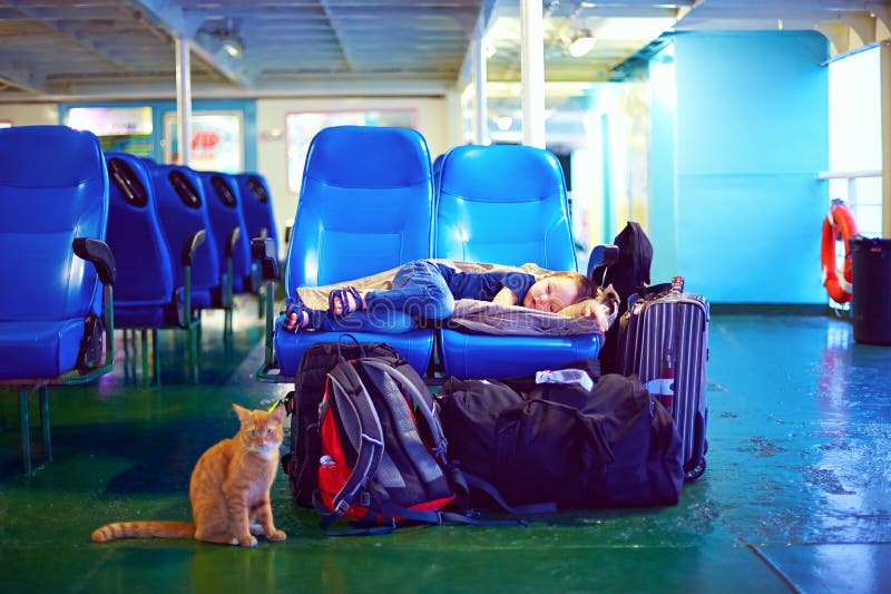 Boy Sleeps on Seats during Exhausting Journey on Ferry Boat Stock Photo