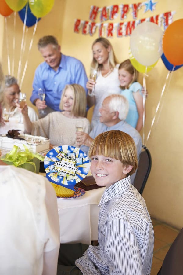 Boy Smiling With Family Having A Retirement Party