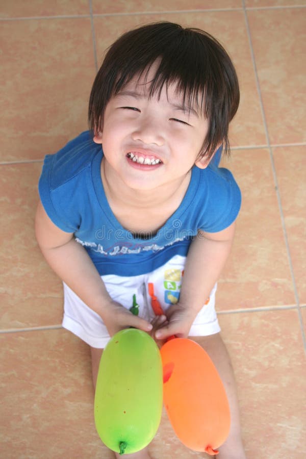 Boy smiling & holding balloons