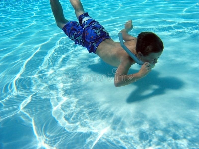 Joven chico tubo respirador él paloma sobre el más bajo de piscina.