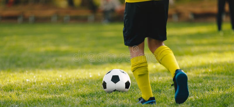 Boy Soccer Player Running After Ball. Grass Football Venue Stock Photo