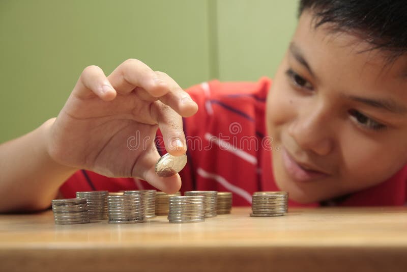 Boy Stacking a Pile of Coins royalty free stock images Boy Stacking a Pile of Coins royalty free stock images