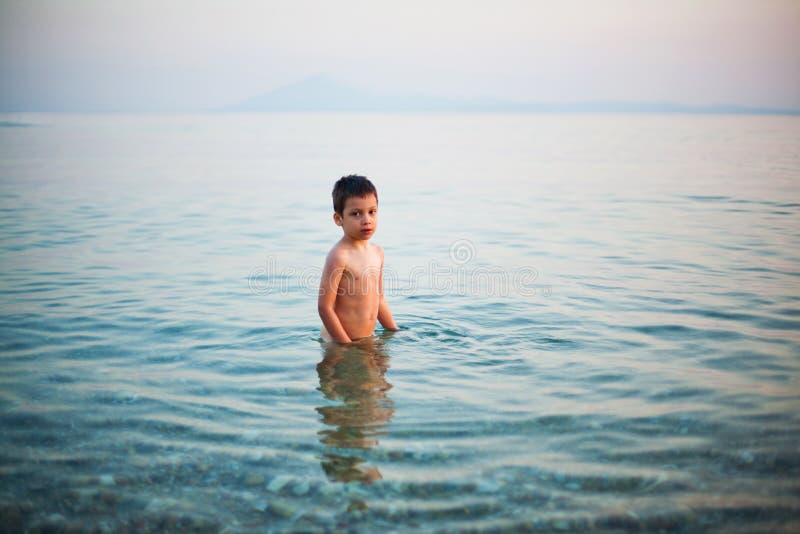 Boy standing in shallow water royalty free stock photos