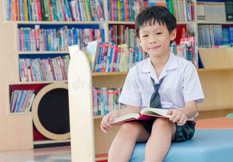 Boy student reading book in library