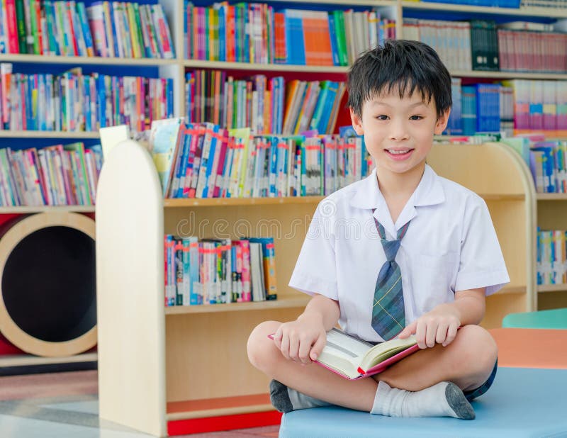 Boy student reading book in library