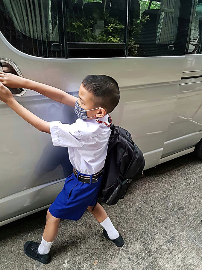 Boy, student, wearing mask Opening the door of the school bus to travel to school to study Prevention of Covit-19 royalty free stock images Boy, student, wearing mask Opening the door of the school bus to travel to school to study Prevention of Covit-19 royalty free stock images