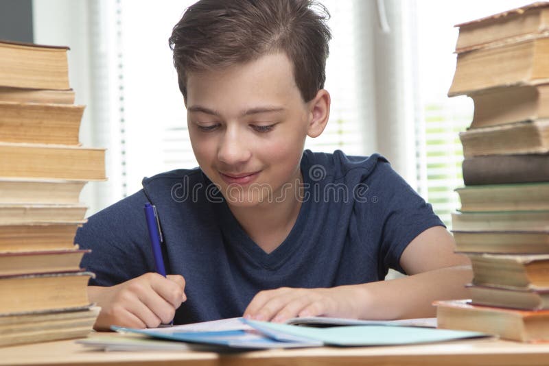 Boy studing at table on blue background and many book