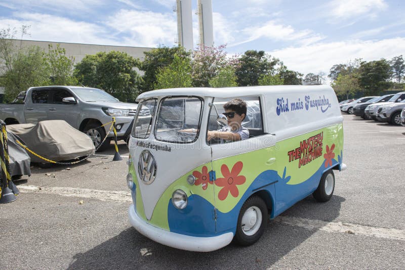 Atibaia - Brazil, October 7, 2022: Boy in sunglasses posing in a miniature van replica of the Scooby Doo mystery machine and the gang, Shaggy, Fred, Daphne and Velma are famous cartoon. Atibaia - Brazil, October 7, 2022: Boy in sunglasses posing in a miniature van replica of the Scooby Doo mystery machine and the gang, Shaggy, Fred, Daphne and Velma are famous cartoon