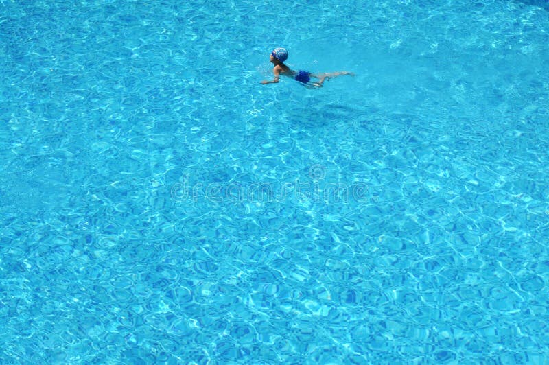 A boy swim in blue clear water