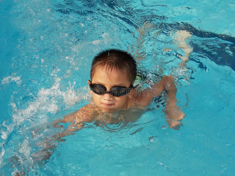 Einen kleinen asiatischen Jungen im Schwimmbad.