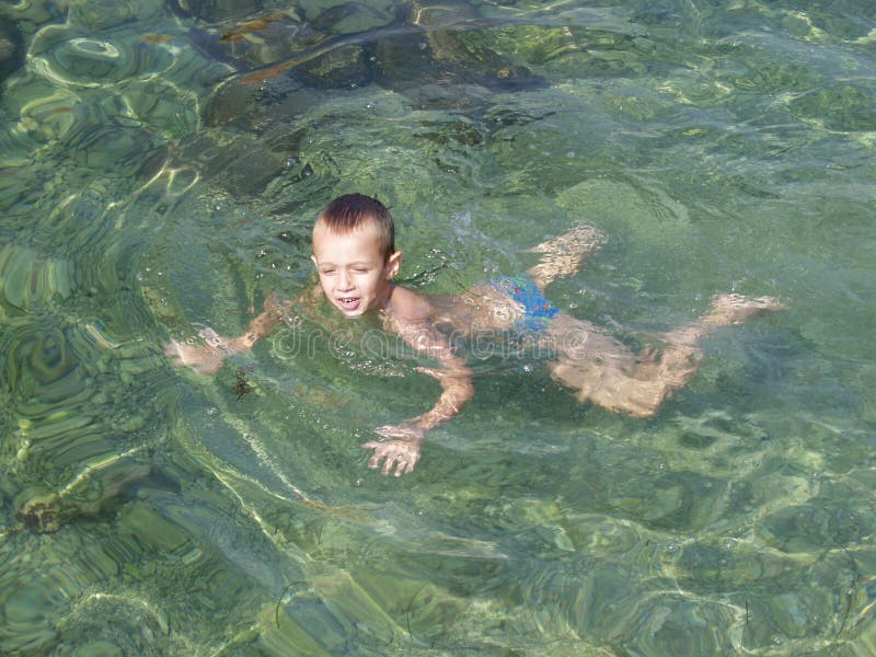 Boy swimming in crystal clear sea