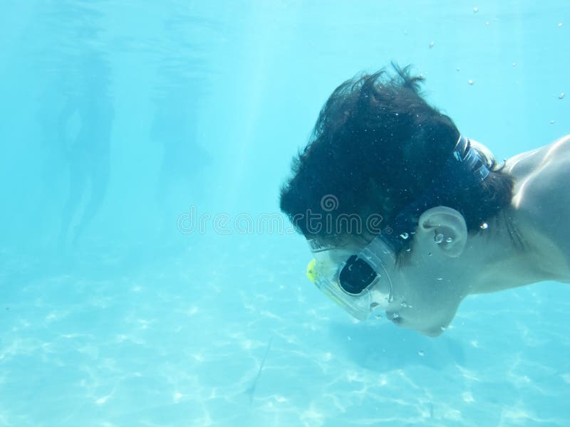 Boy swimming underwater in ocean