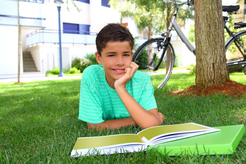 Boy teen studying laying green grass garden