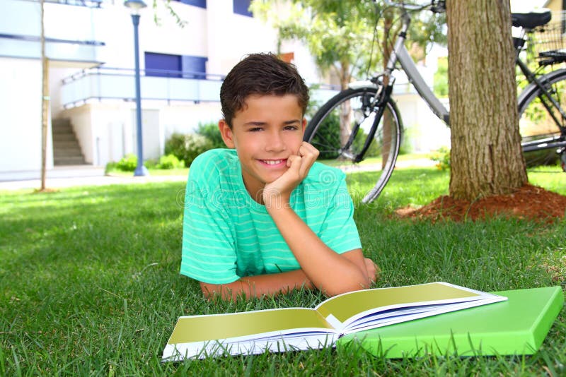 Boy teen studying laying green grass garden