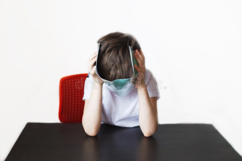 The boy is tired of doing homework. stock image