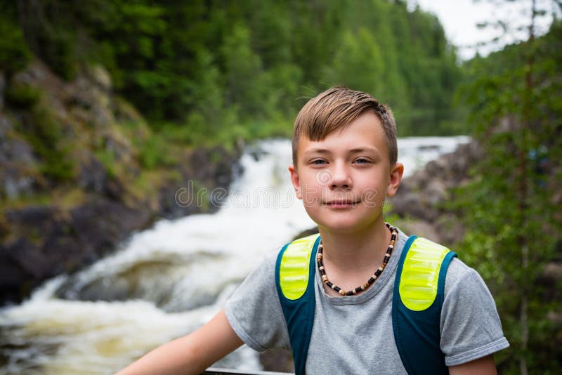 Boy tourist standing near the mountain waterfall stock photography