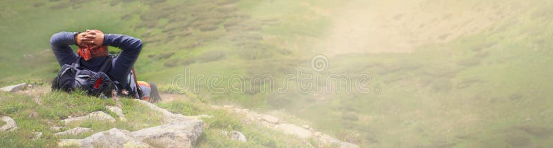 Man traveler with backpack enjoying and relaxing on hill top with cityscape background. Summer holiday and vacation trip in the Caucasian mountains. Man traveler with backpack enjoying and relaxing on hill top with cityscape background. Summer holiday and vacation trip in the Caucasian mountains