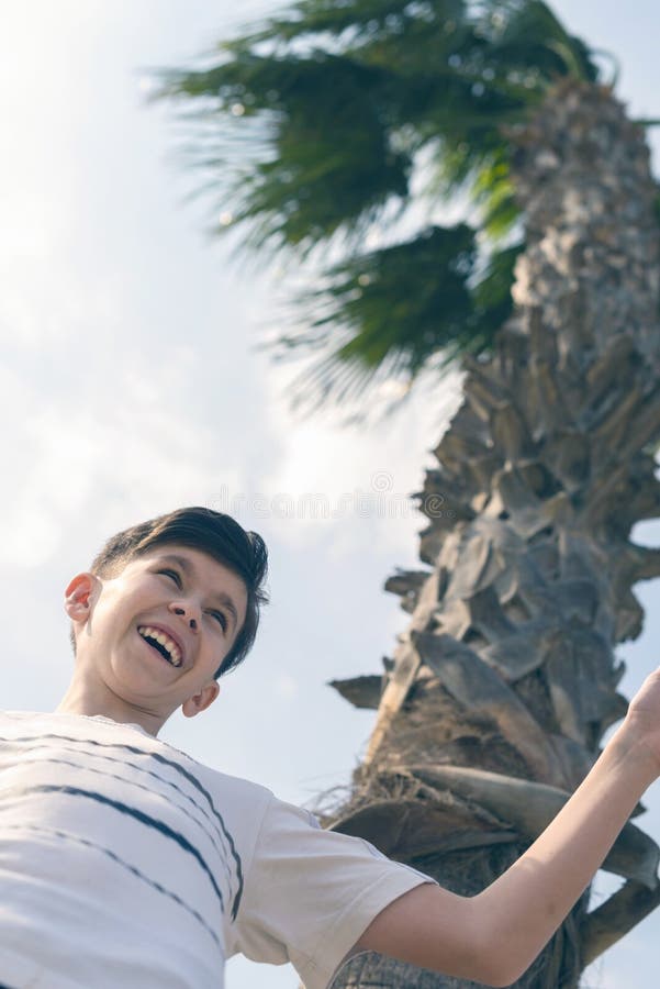 Boy under coconut palm tree and sky