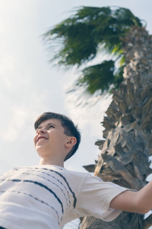 Boy under coconut palm tree and sky