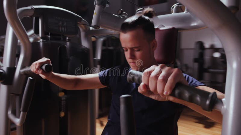 Boy using chest press machine in gym - close up