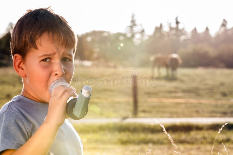 Boy using inhaler for asthma royalty free stock image