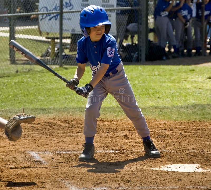 A boy watching for the ball to cross the plate.