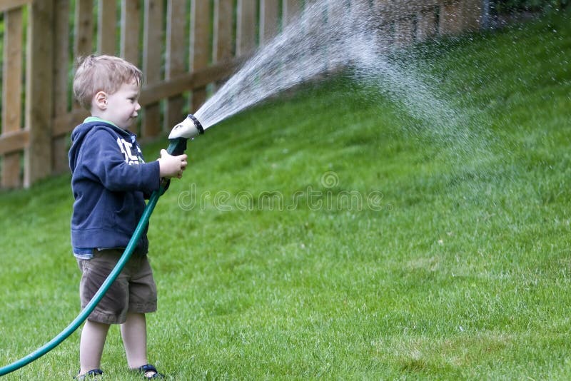 Boy watering garden stock ph