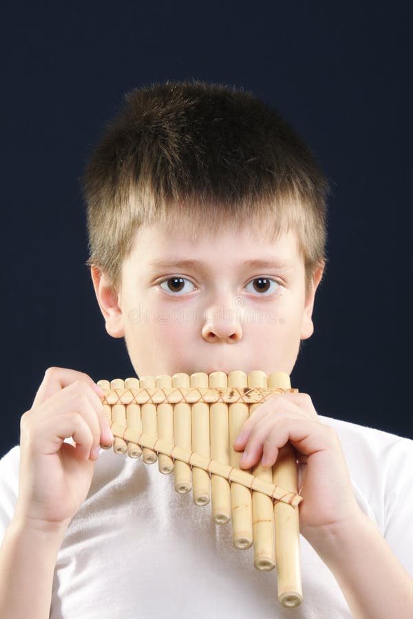 Boy in white playing panflute royalty free stock photo