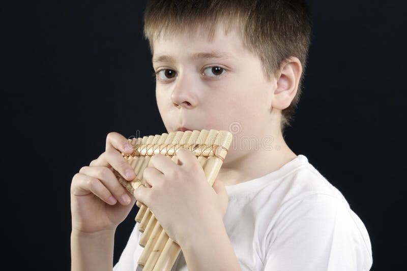 Boy in white shirt playing bamboo panflute stock photos