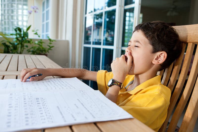 Boy Yawning As he Does His Homework Stock Image - Image of read
