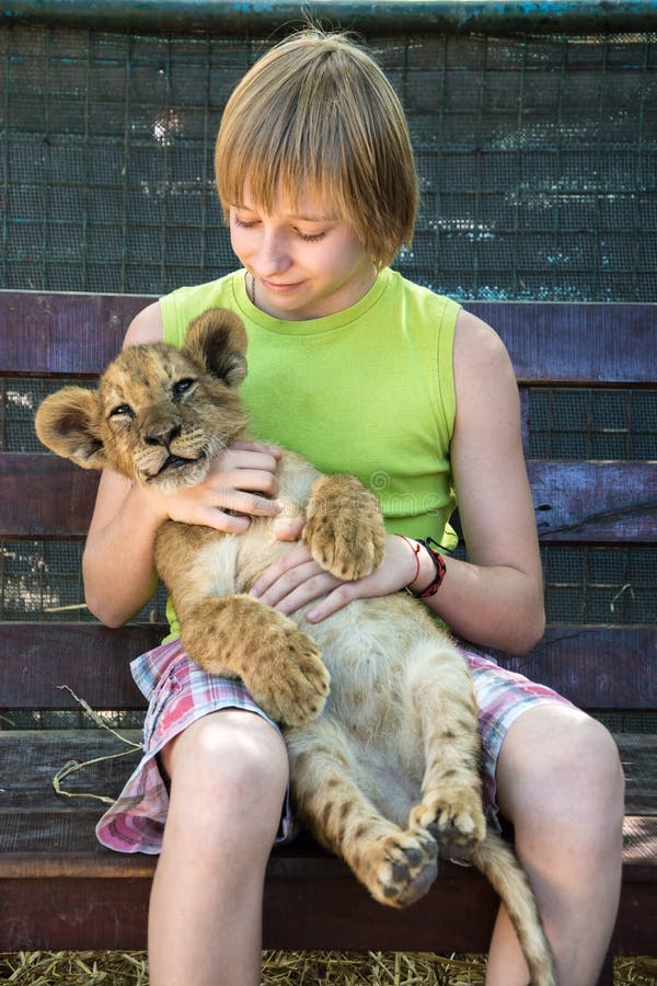 Boy with a young lion in hands