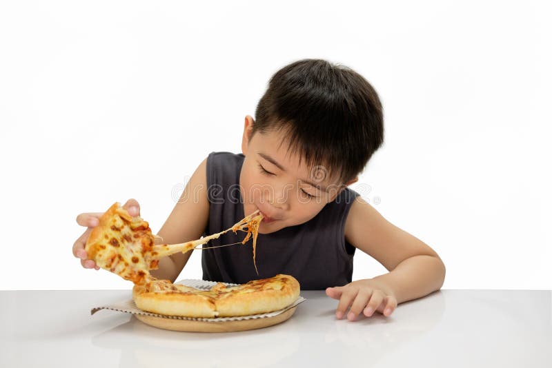 Asian boy happy to eat pizza with a hot cheese is melting and stretching on a wooden pad. Isolated on white background, choose focus point. Asian boy happy to eat pizza with a hot cheese is melting and stretching on a wooden pad. Isolated on white background, choose focus point.