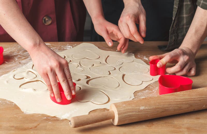 Boyfriend and girlfriend, making cookies for Valentine`s Day tog stock images Boyfriend and girlfriend, making cookies for Valentine`s Day tog stock images