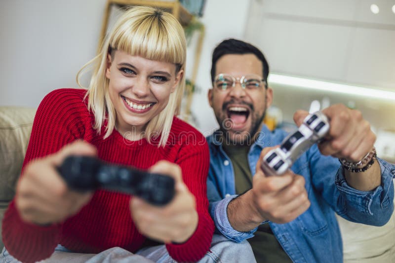 Man disappointed while playing video game with girlfriend at home stock  photo